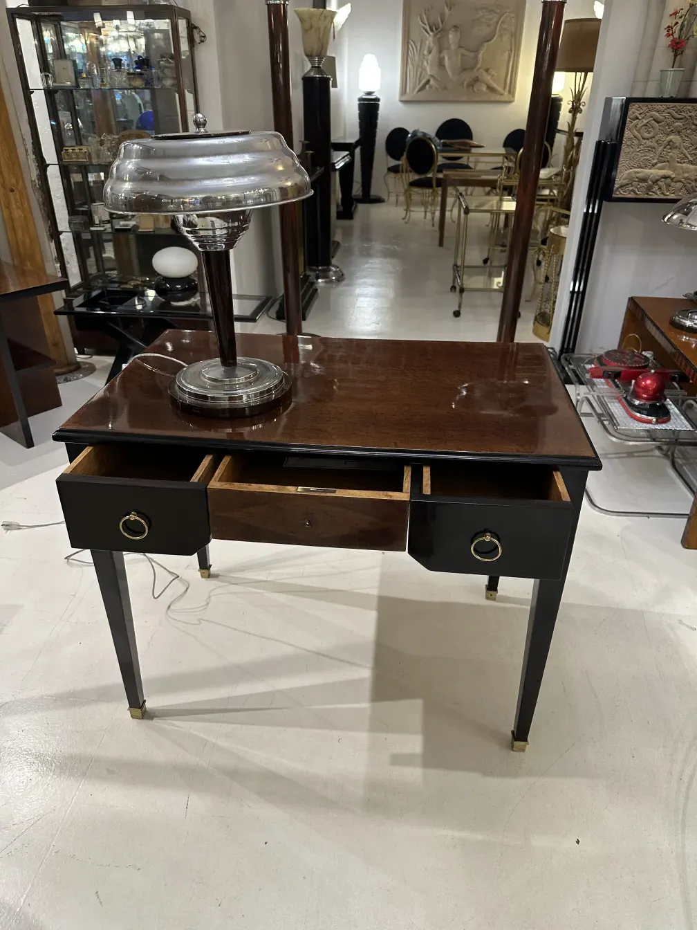 Escritorio antiguo de madera con lámpara y espacio de almacenamiento.