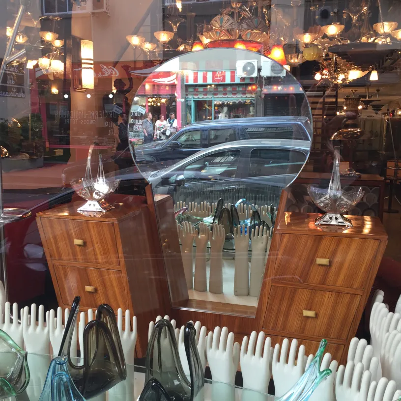 Round mirror in front of antique ceramic objects with soft light