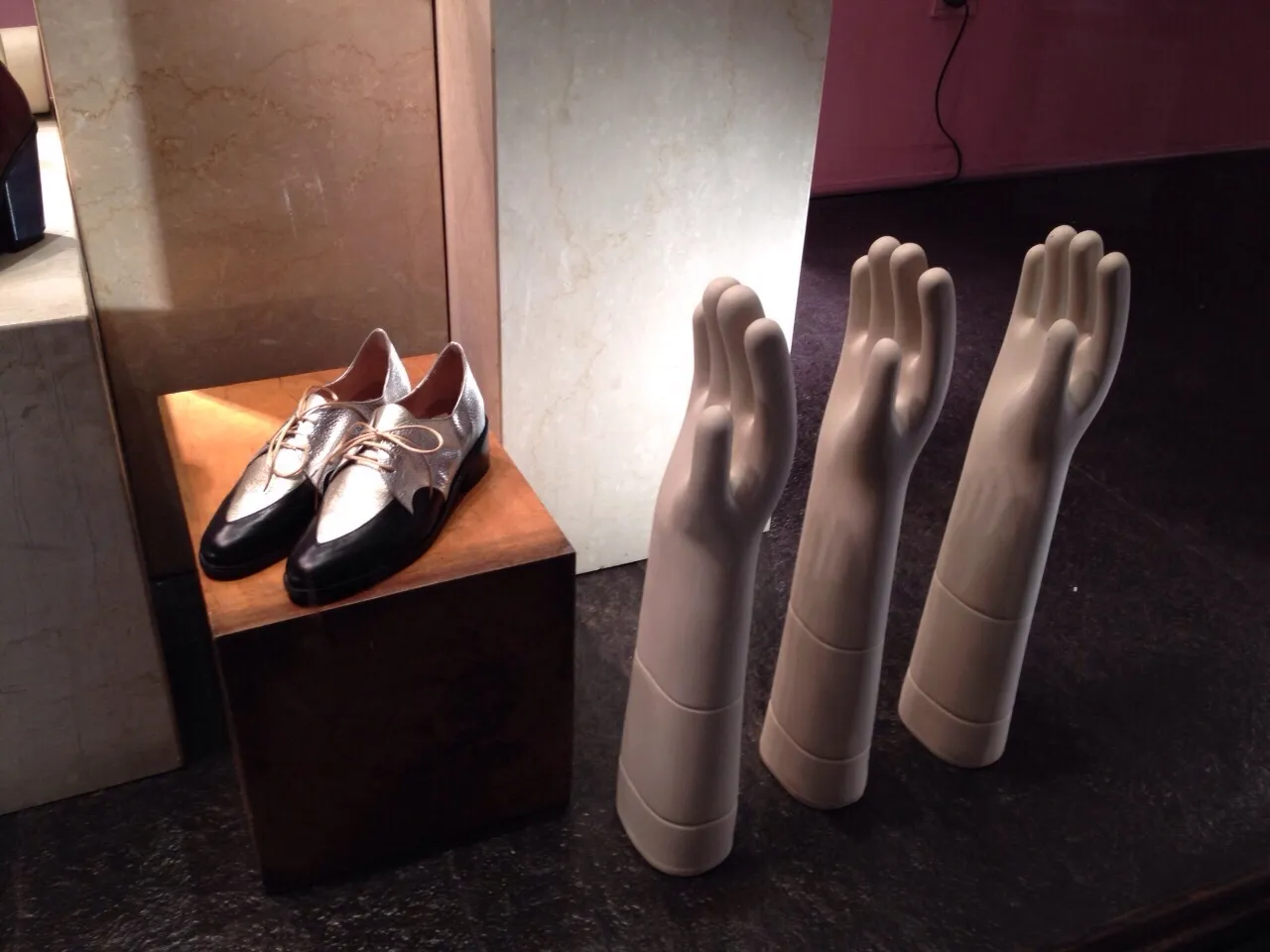 Anzeige von Handmannequins und Schuhen mit antiker Keramik im Hintergrund.