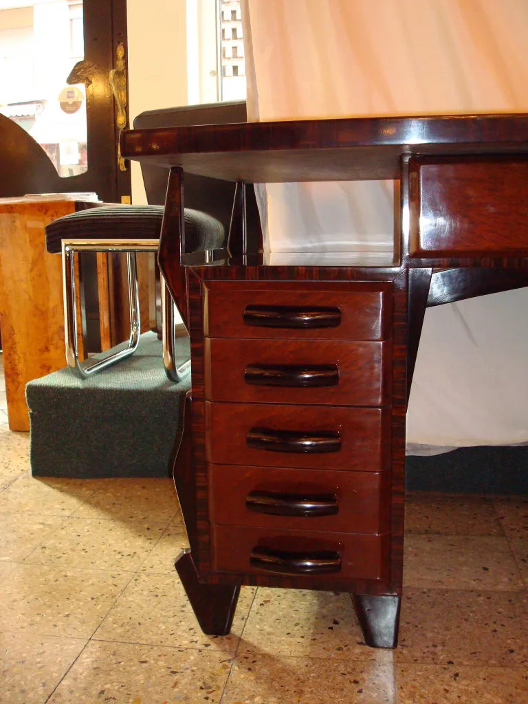 Bureau ancien avec quatre tiroirs et un style distinctif.