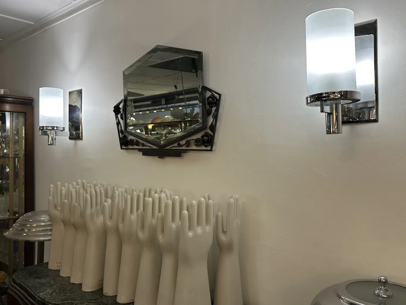 Cerámica antigua con formas de manos blancas en ambiente decorativo.