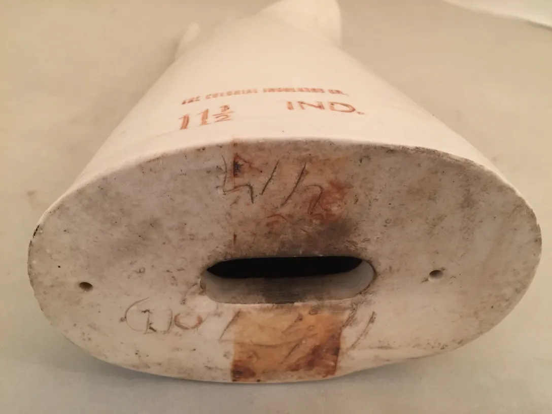 Vista inferior de um item de cerâmica antiga com detalhes visíveis e texto