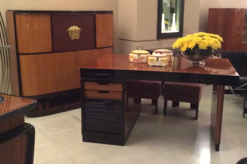 Bureau ancien avec des fleurs jaunes et des accessoires décoratifs.