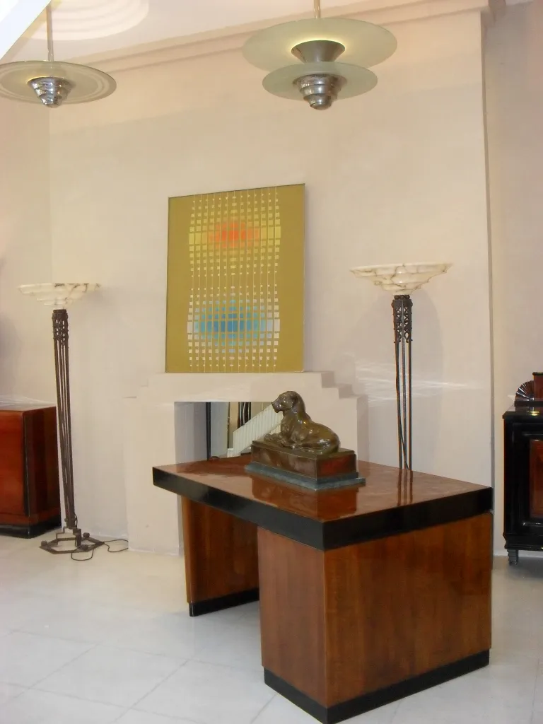 escritorio antigo de madeira com lâmpadas e arte moderna