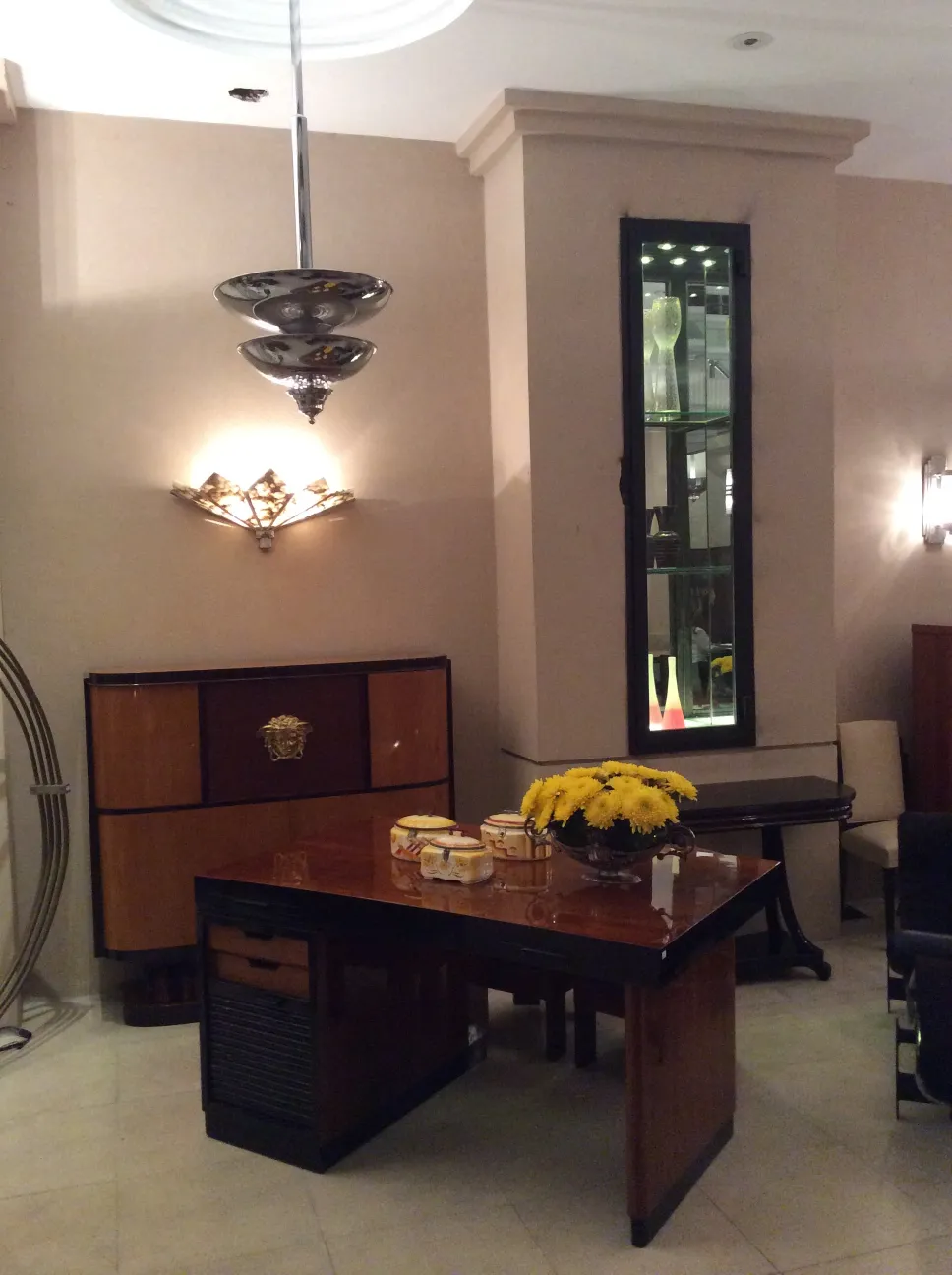 Mesa antiga com decoração brilhante e flores amarelas.