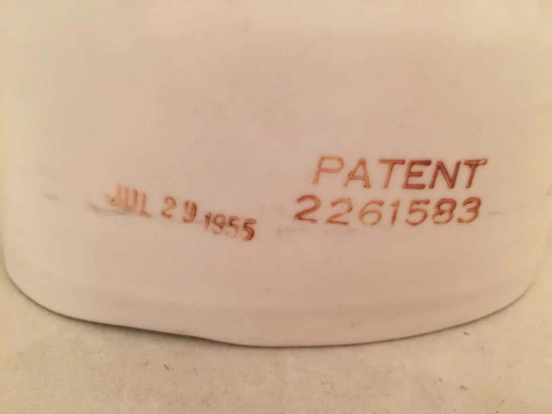 Cerâmica antiga com detalhe de patente e data de 1955.
