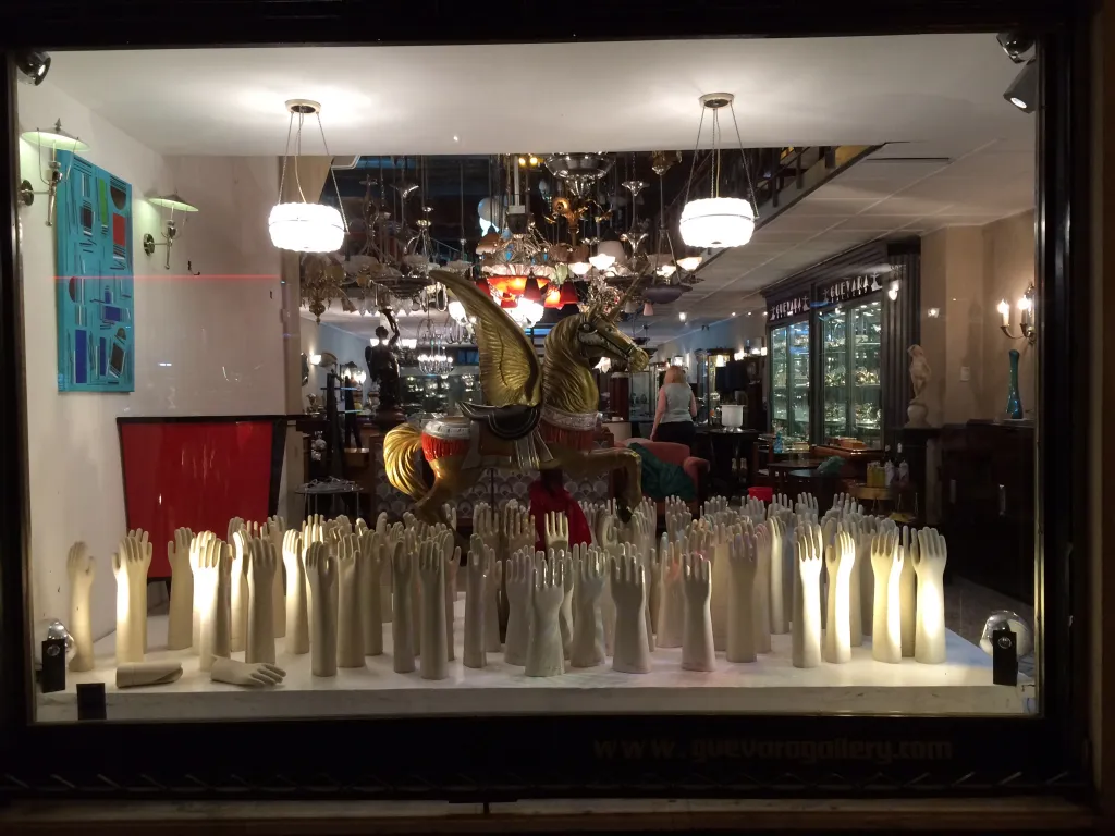 Exhibición de manos de cerámica antigua iluminadas en vitrina