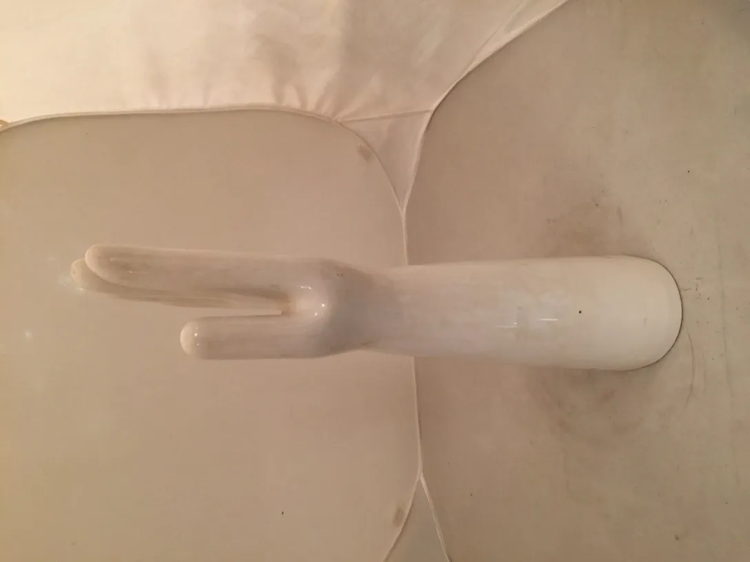 Antiga cerâmica branca em forma de mão com detalhes únicos.