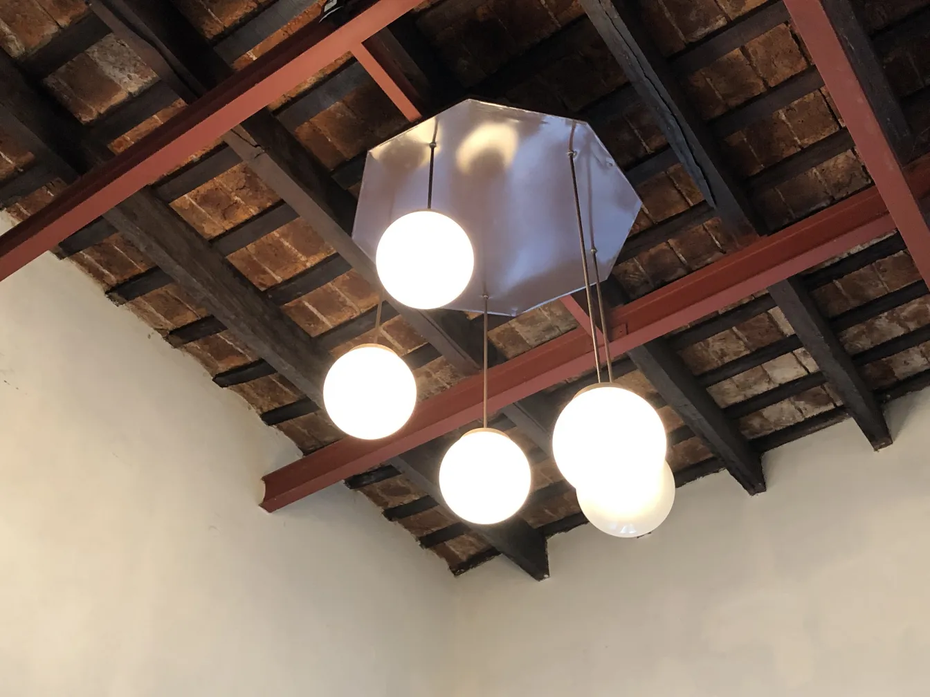 Quattro lampade a sospensione antiche in un soffitto in legno