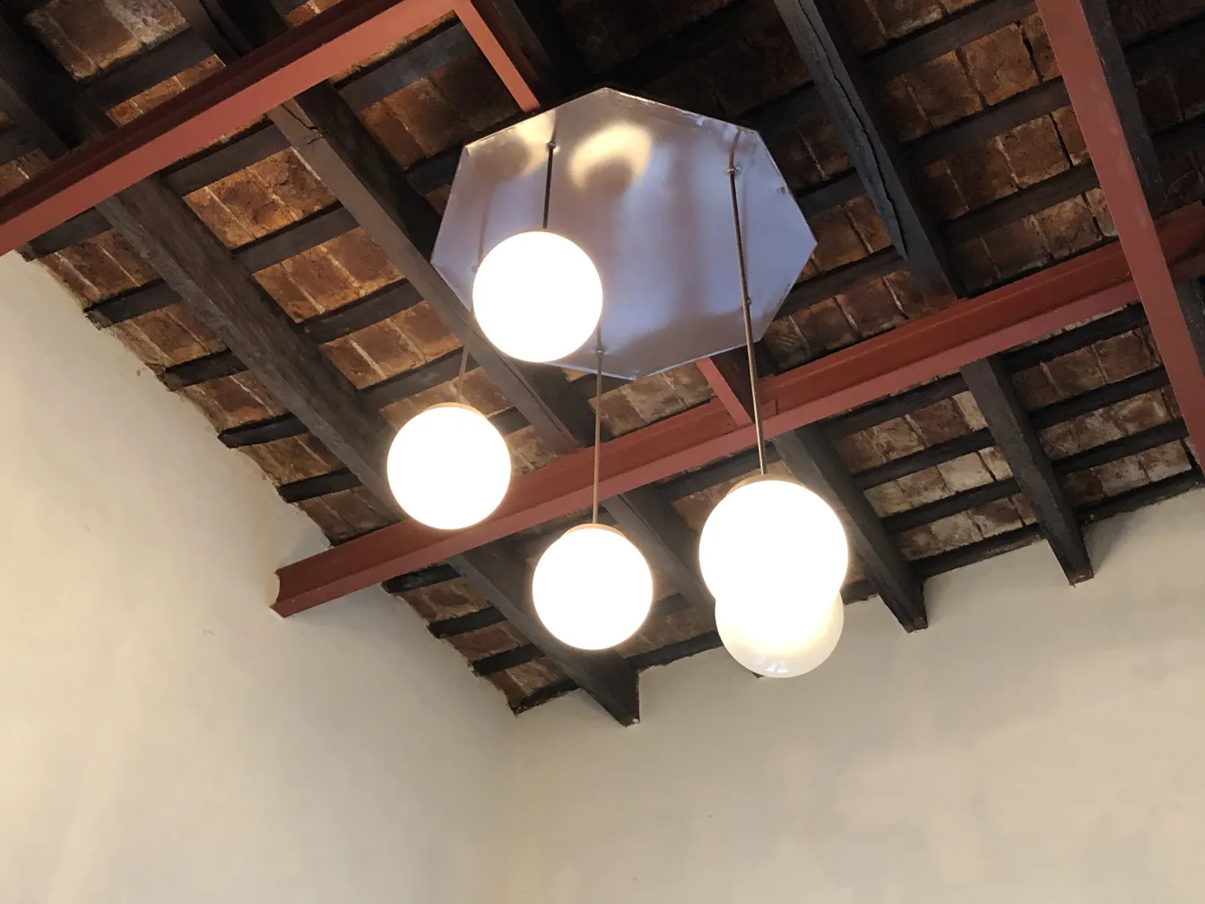 4 lampade a sospensione antiche con sfere bianche in un ambiente accogliente