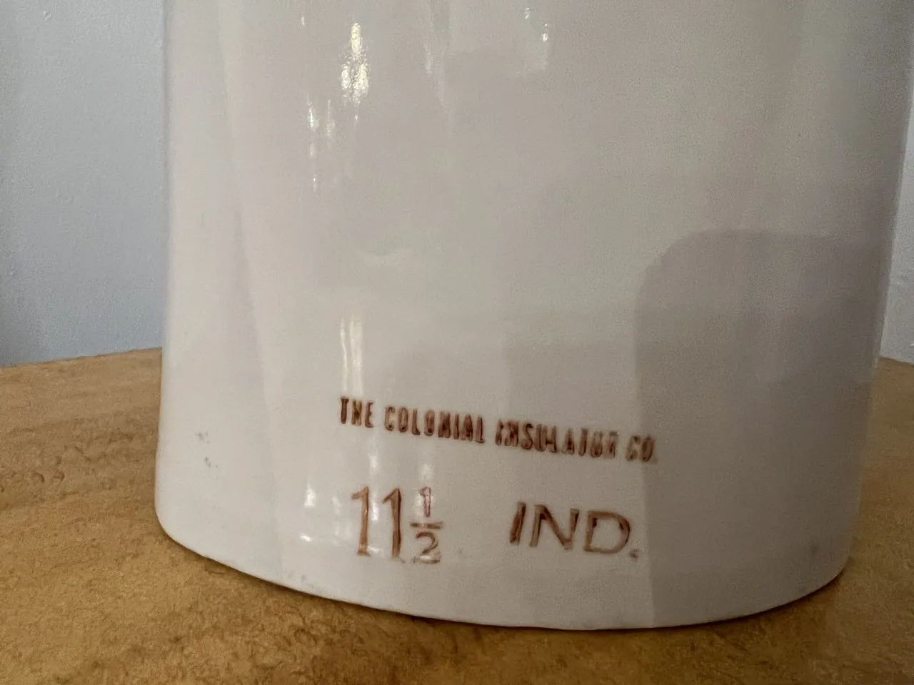 Antica ceramica decorativa bianca con iscrizione. Contesto neutro.