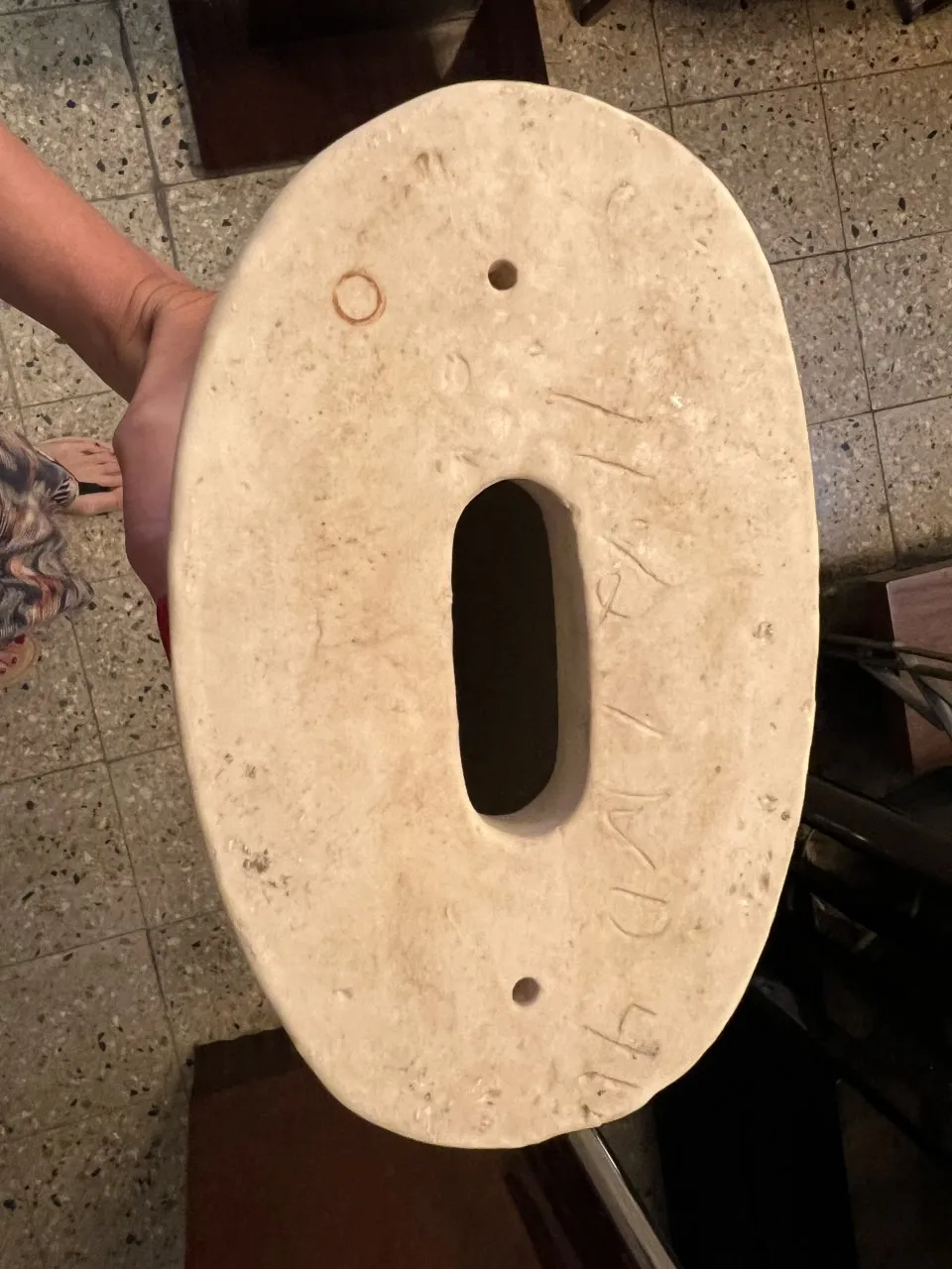 Vista dall'alto di una scultura in ceramica antica a forma ovale.