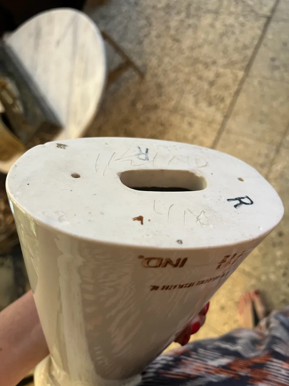 Base de cerámica antigua con inscripciones visibles, objetos decorativos