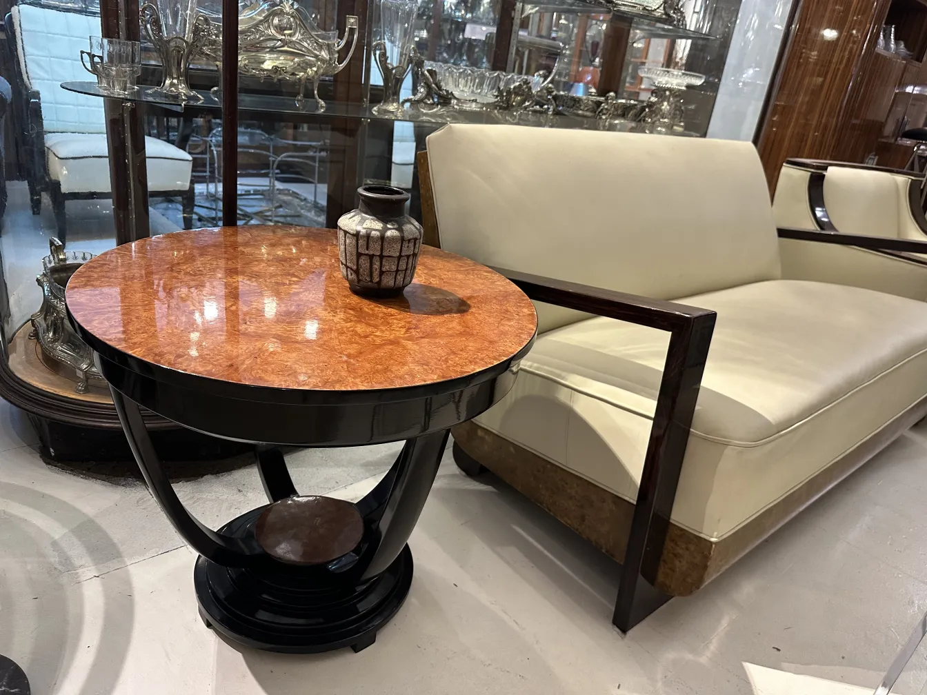 Vaso de cerâmica antiga sobre mesa decorativa com superfície brilhante.