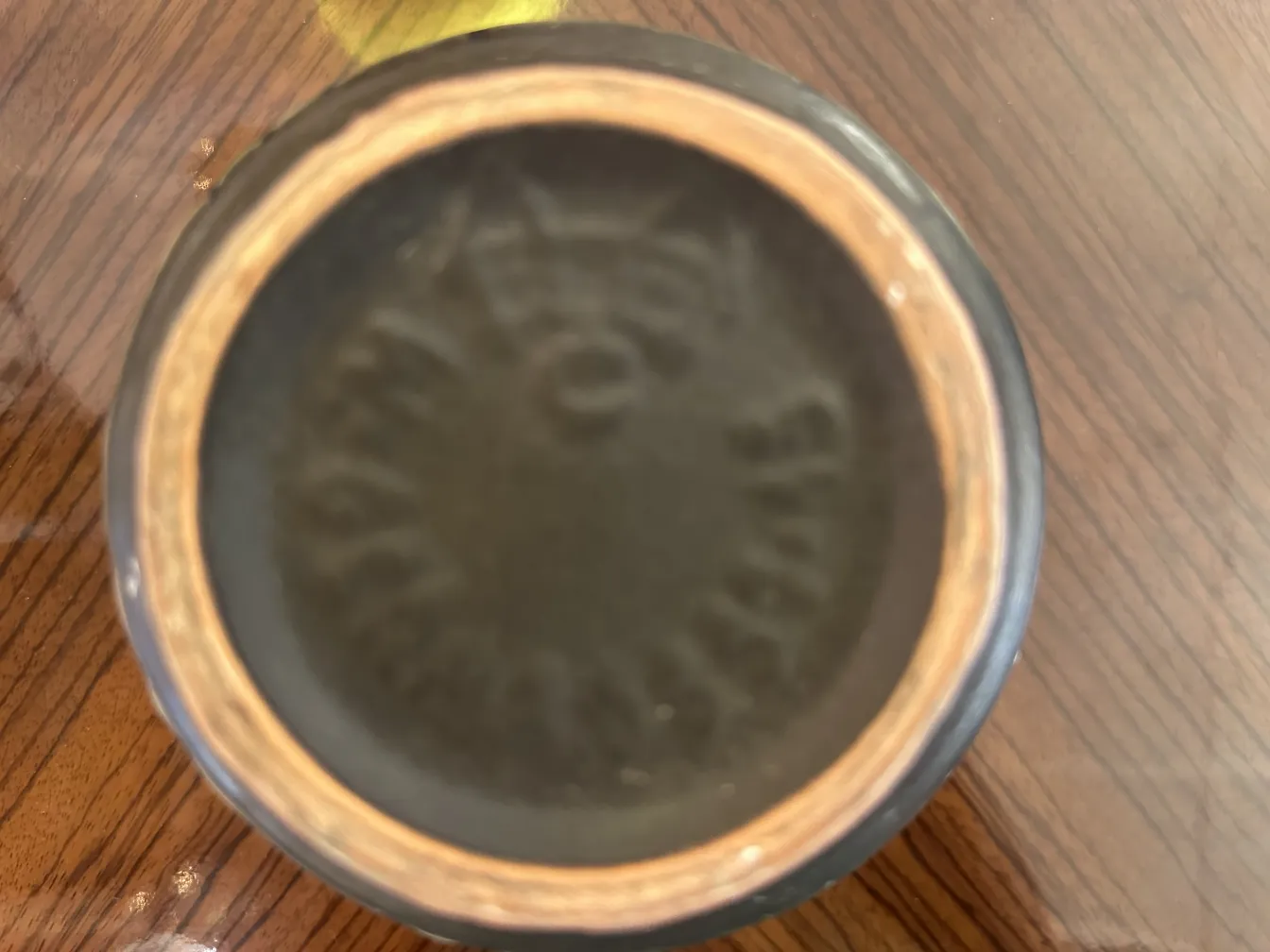 Vista del fondo di una ceramica antica con dettagli artigianali.