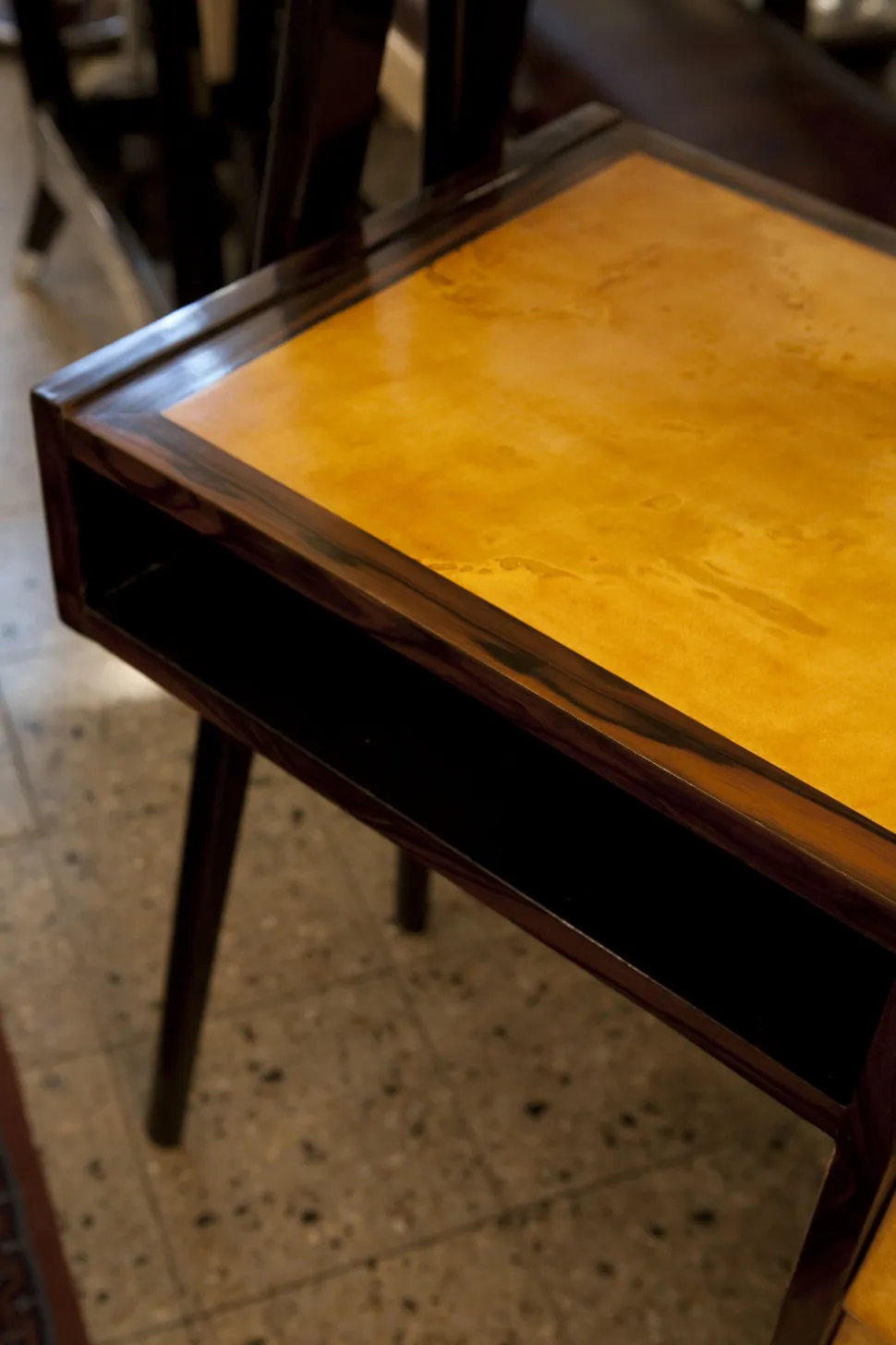 Antique desk with a golden surface and wooden legs