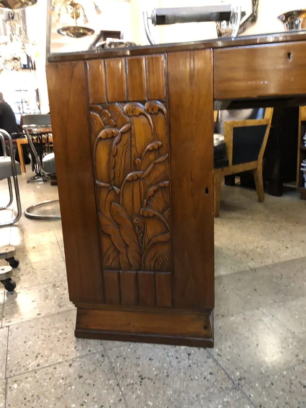 Escritorio antiguo de madera con detalles tallados elaborados en el frente.