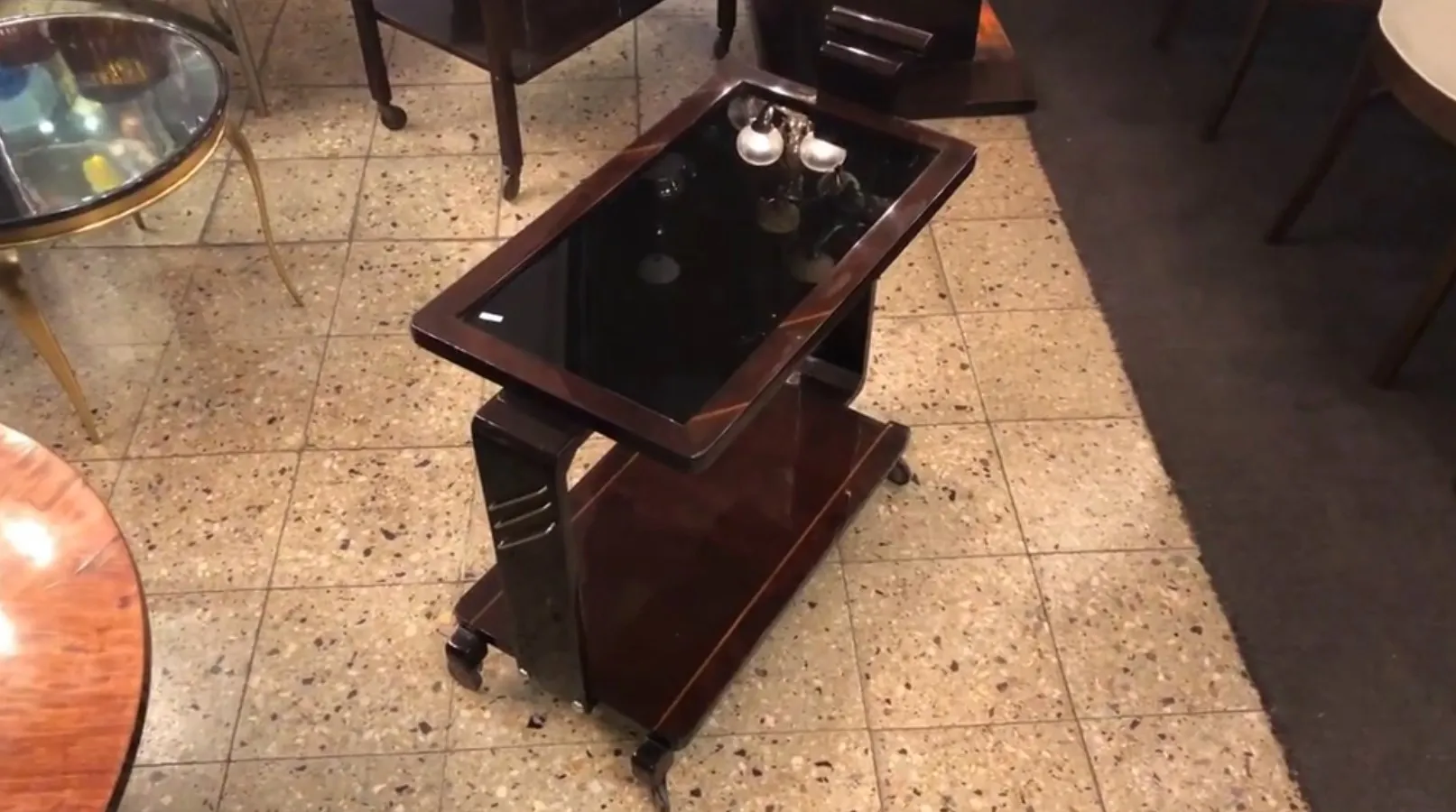 Chariot-bar antique avec verre noir dans un cadre attrayant.