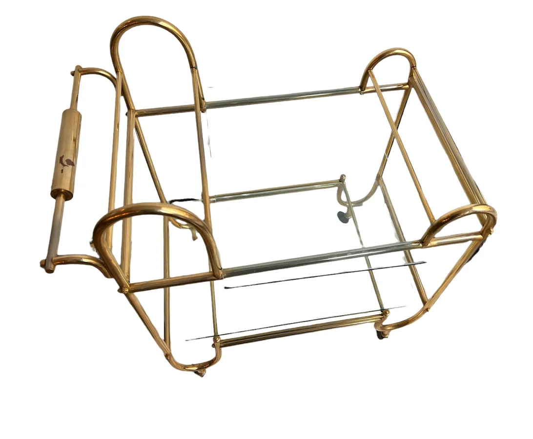 Antique cocktail trolley with elegant design and golden finishes on a plain background.