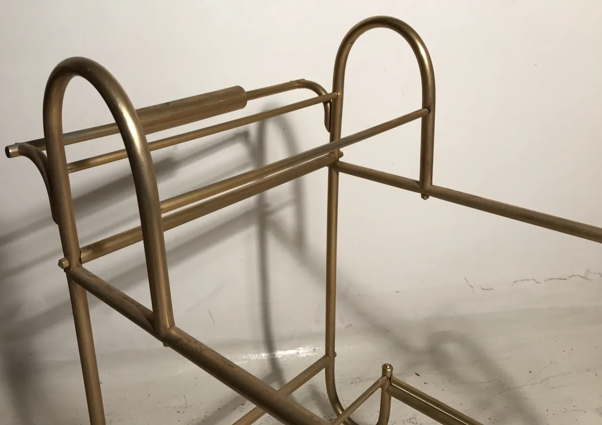 Antique cocktail trolley with a golden frame and elegant design.