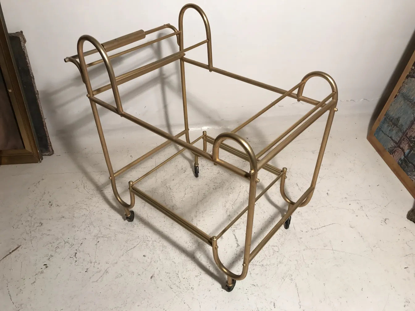 Antique cocktail trolley with golden rolls in a neutral background.