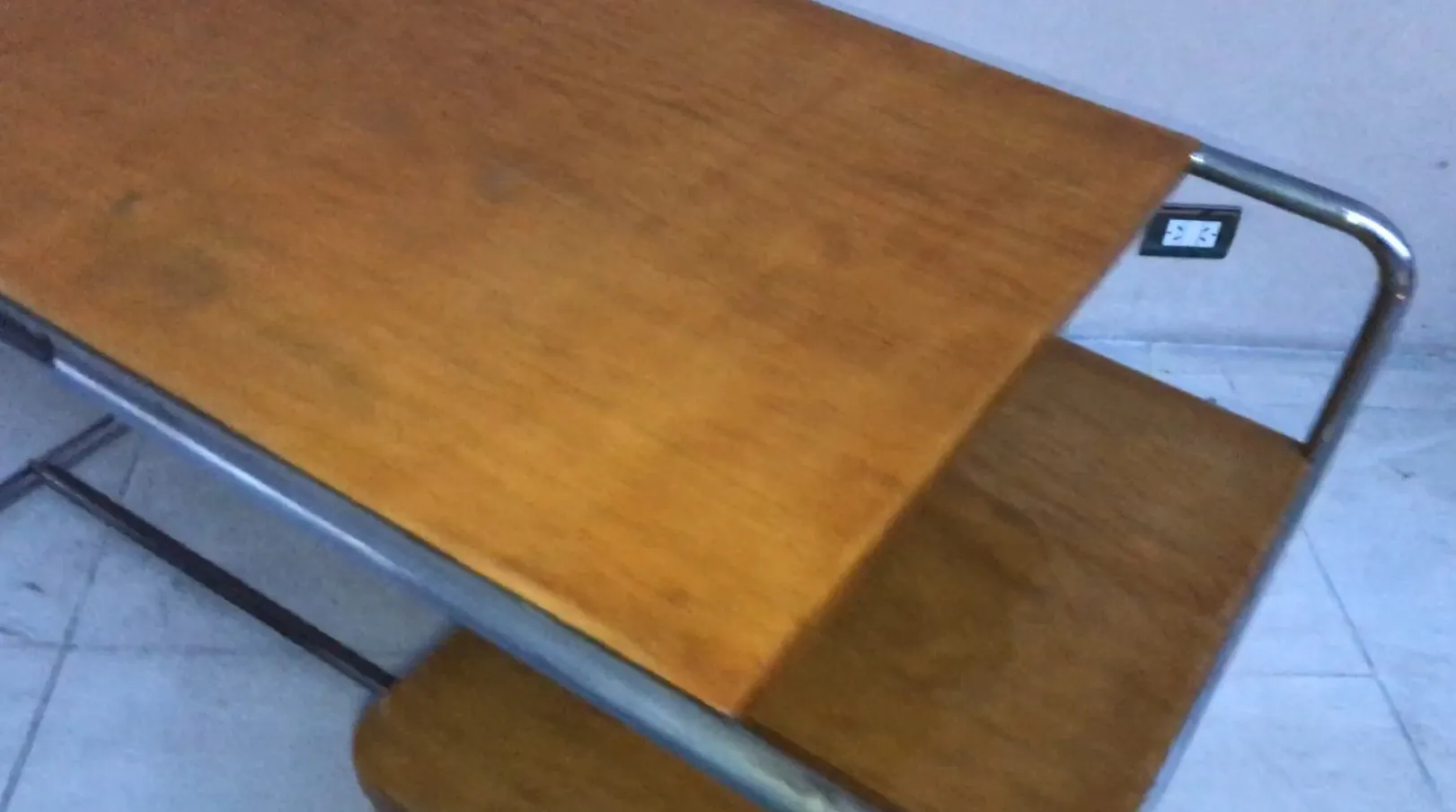 Scrivania antica in legno con finitura classica, ambiente semplice.