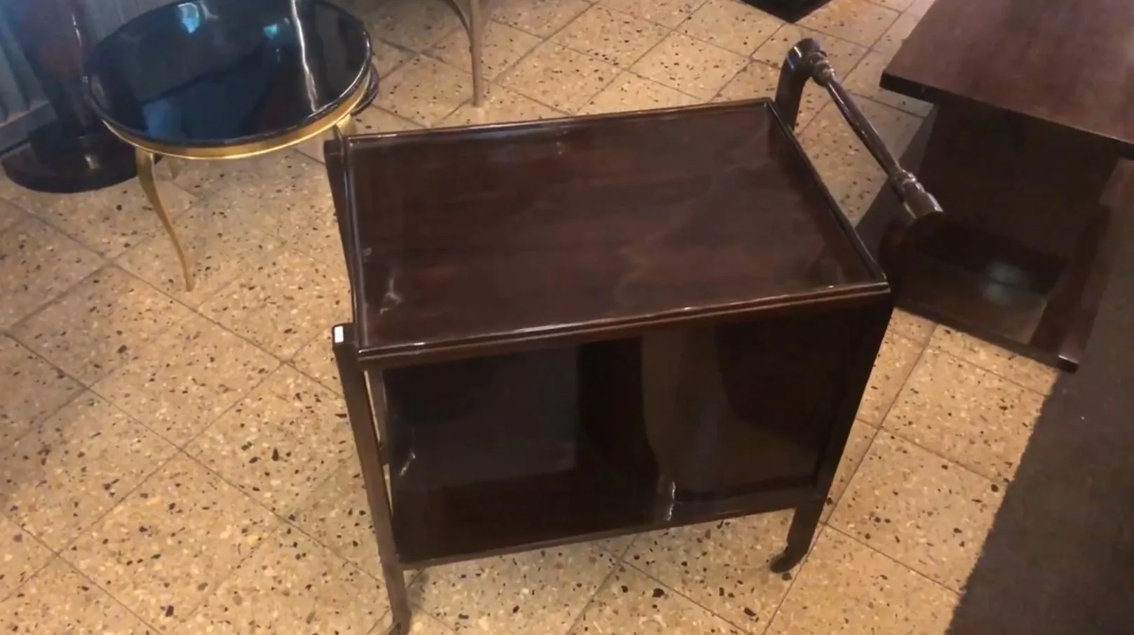 Mesas carrinho antiga com dois prateleiras, em um ambiente de bar.