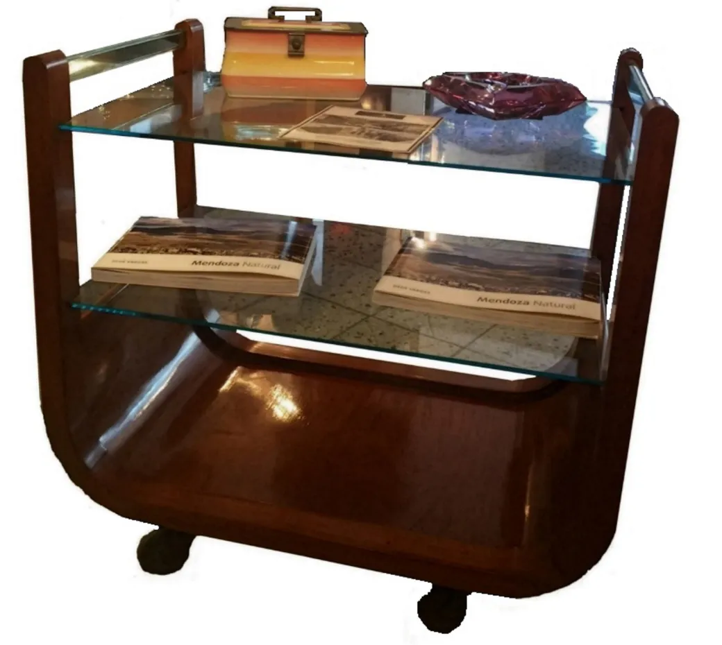 Chariot-bar ancien avec étagères en verre dans un cadre chaleureux.