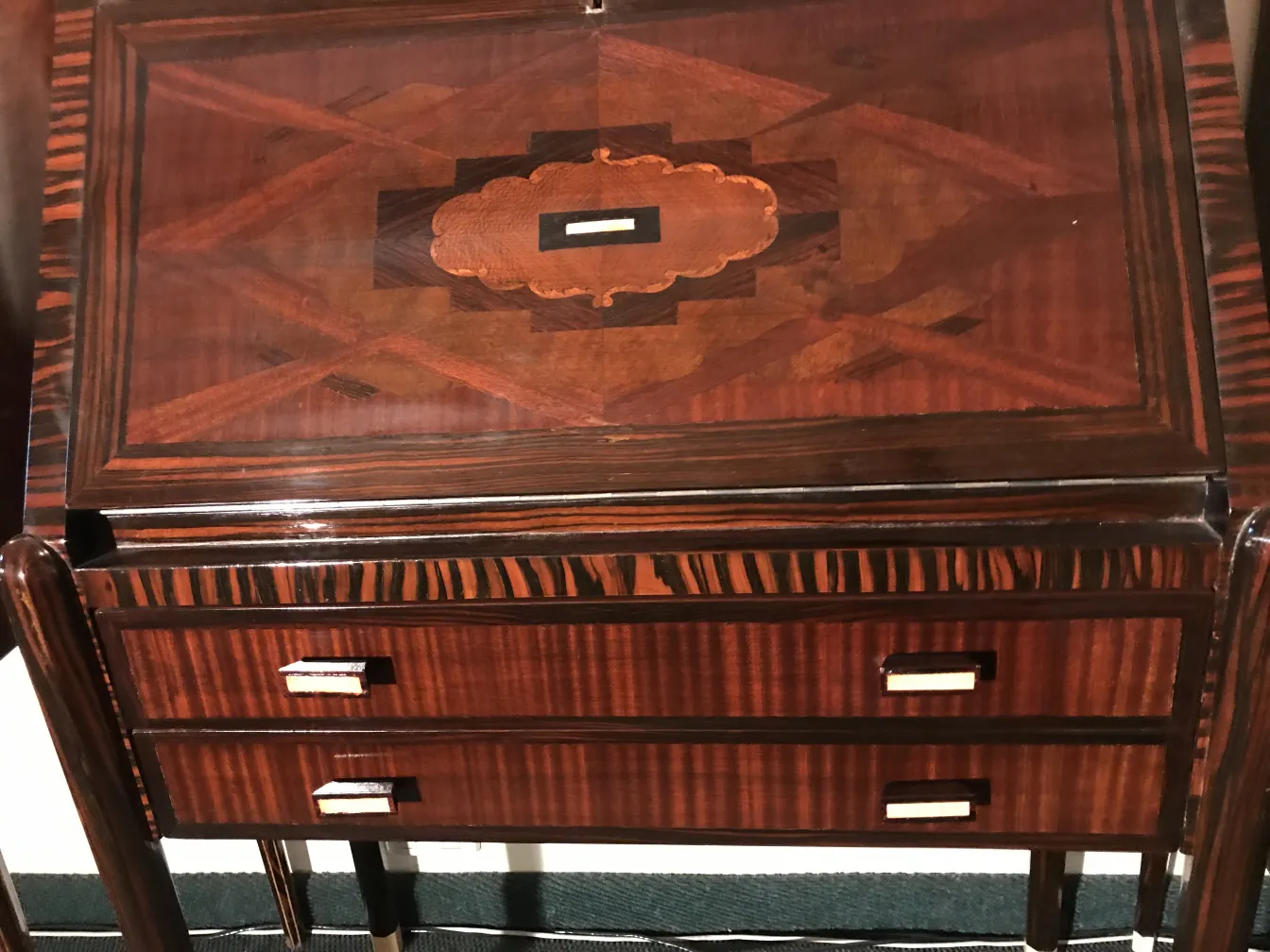 Bureau ancien avec un design complexe et des tiroirs clairs.