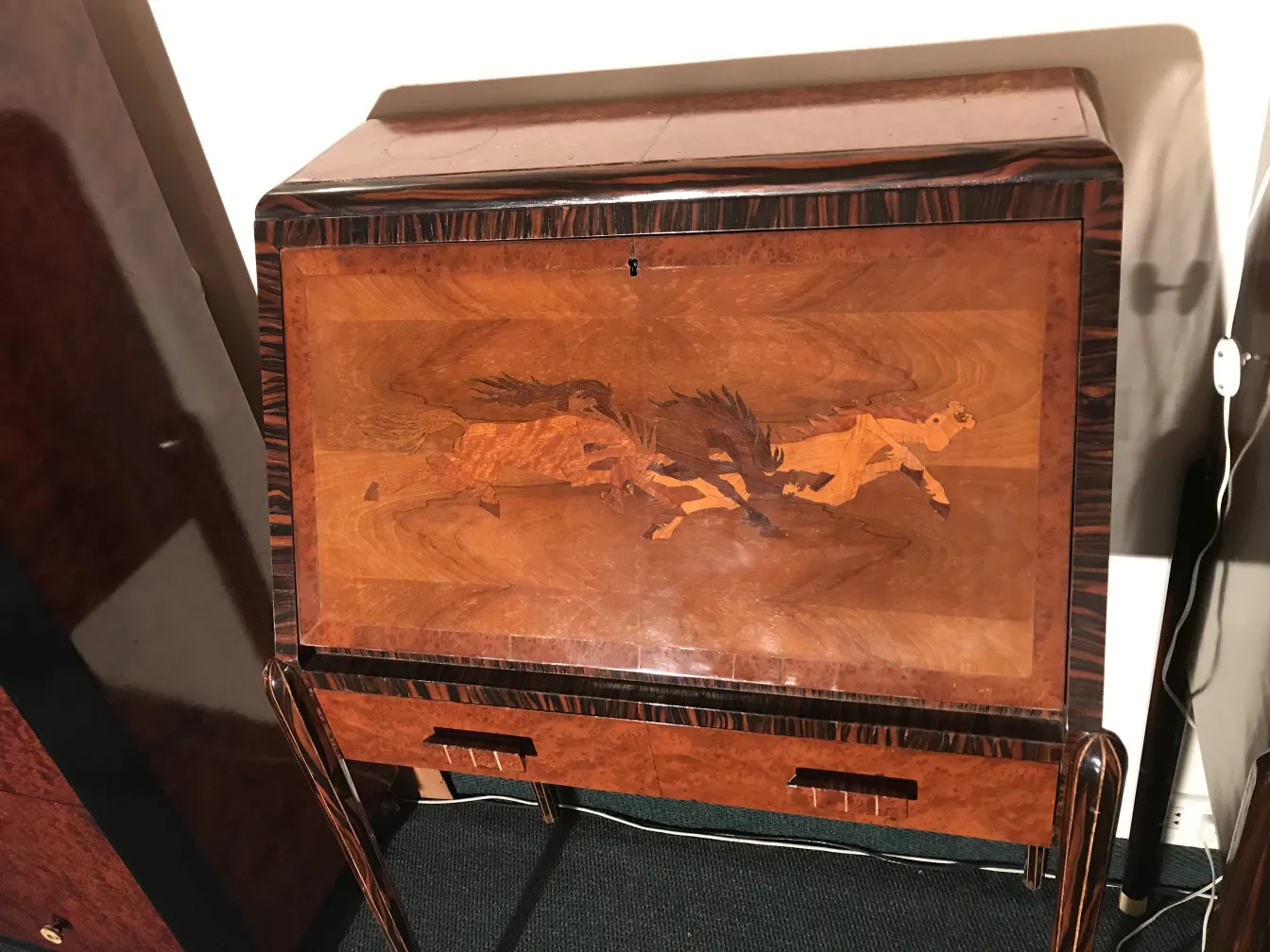 Bureau ancien avec un design de chevaux sur le devant, style élégant.