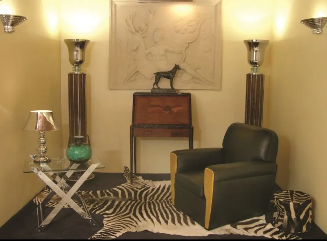 Escritorio antigo em um ambiente elegante com luminárias e uma cadeira.