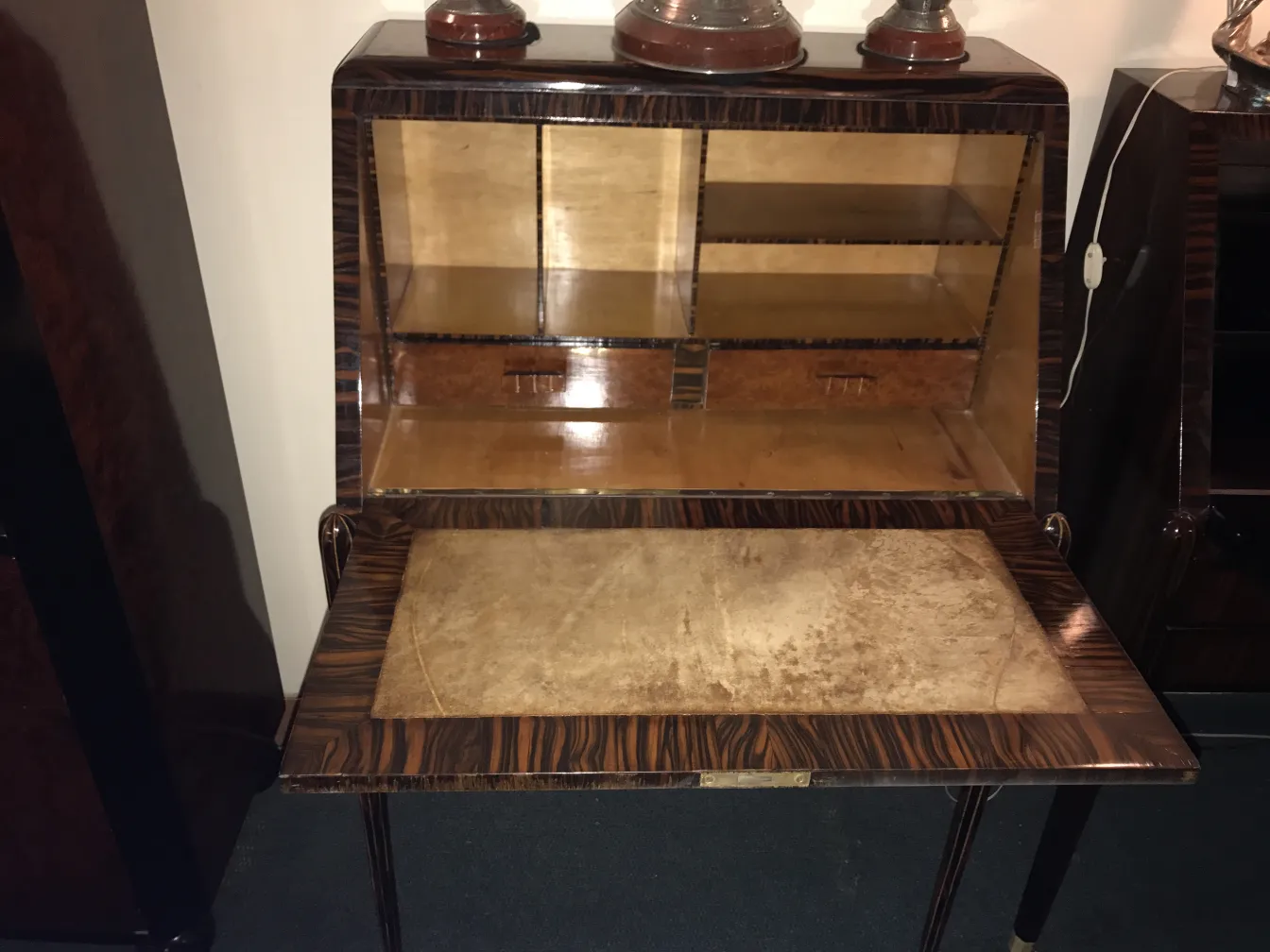 Antique desk with wooden shelves and elegant legs in a classic setting.