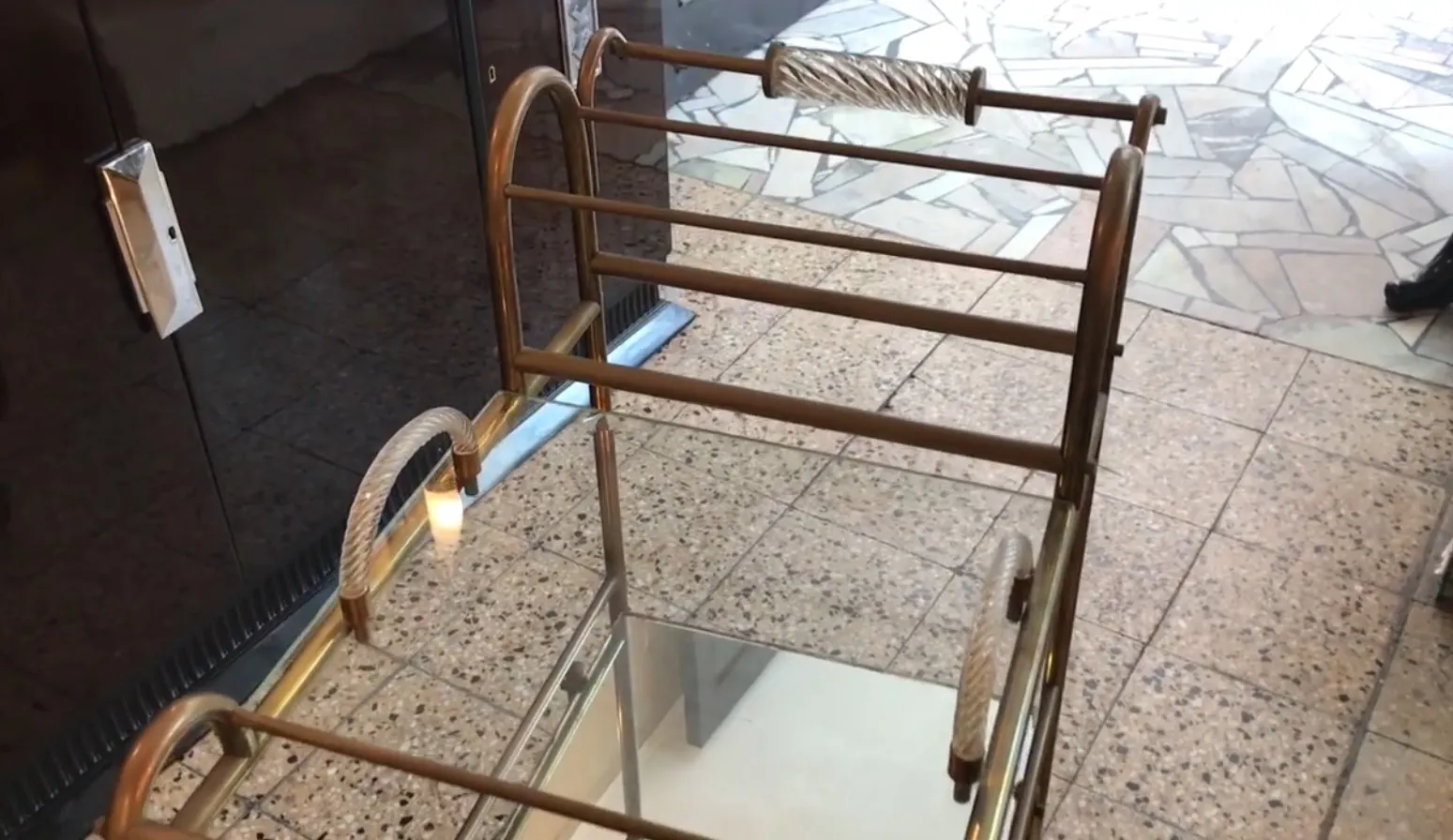 Antique cocktail trolley with elegant metal details, perfect for serving drinks.