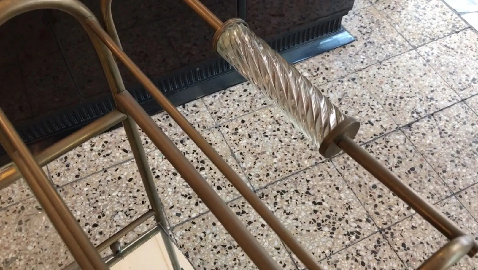 Chariot-bar ancien avec poignées en verre et structure dorée dans un cadre élégant.