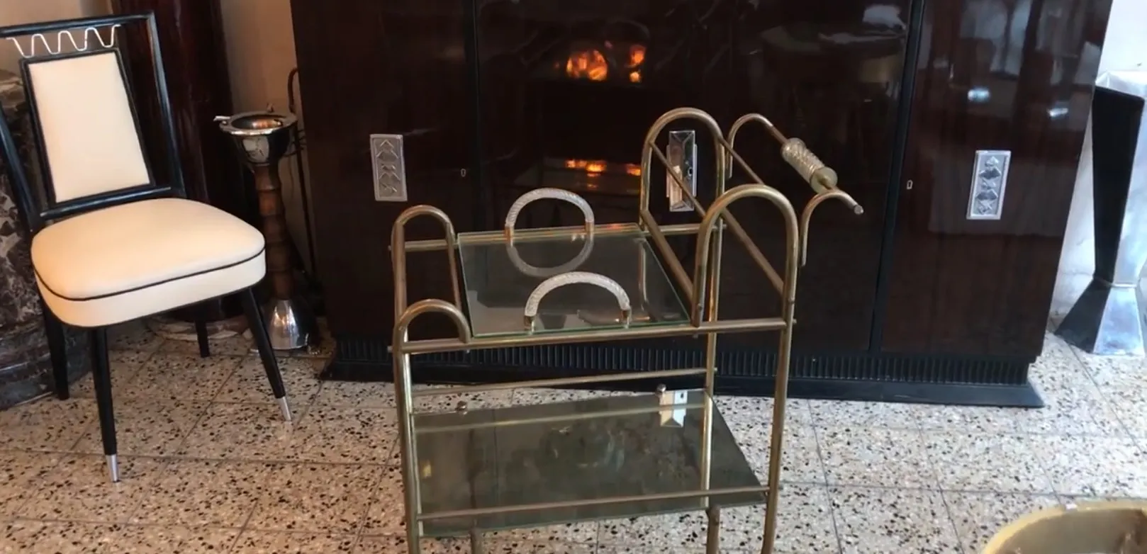 Antique cocktail trolley with glass and metal details in a classic setting.
