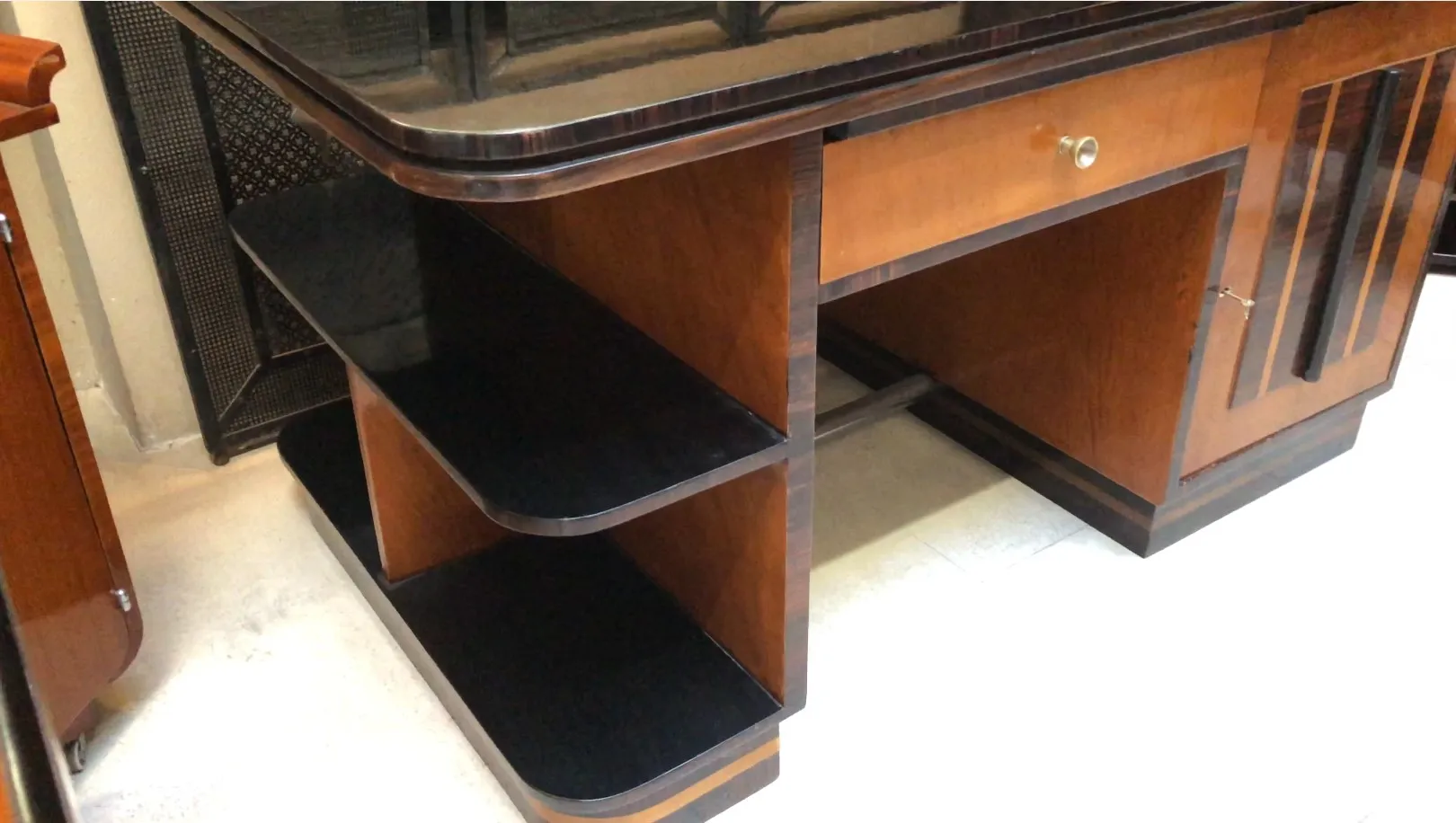 Scrivania antica in legno con scaffali neri. Ambiente elegante e classico.