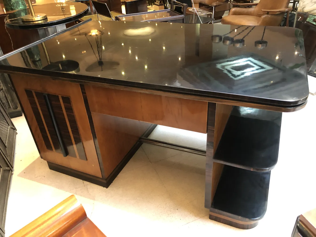 Antique desk with glossy black surface and light wood details.