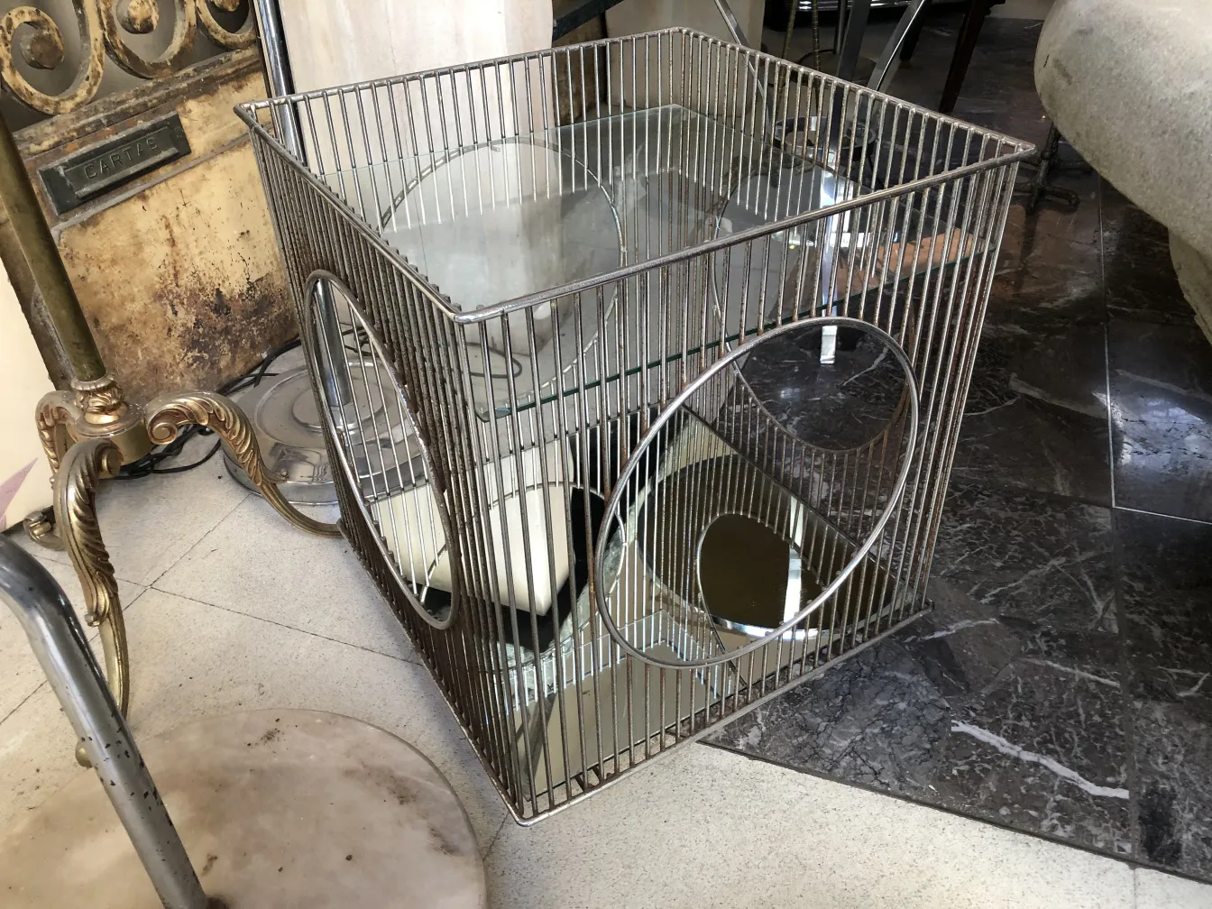 mesa carrito antigua con estructura de metal y reflejos.