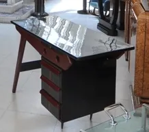 Antique desk with black finish and red details, featuring two drawers