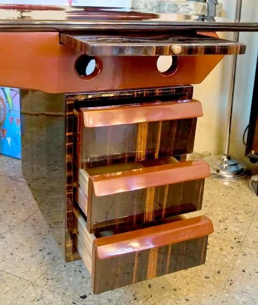 Bureau ancien avec trois tiroirs et deux ouvertures pour câbles.