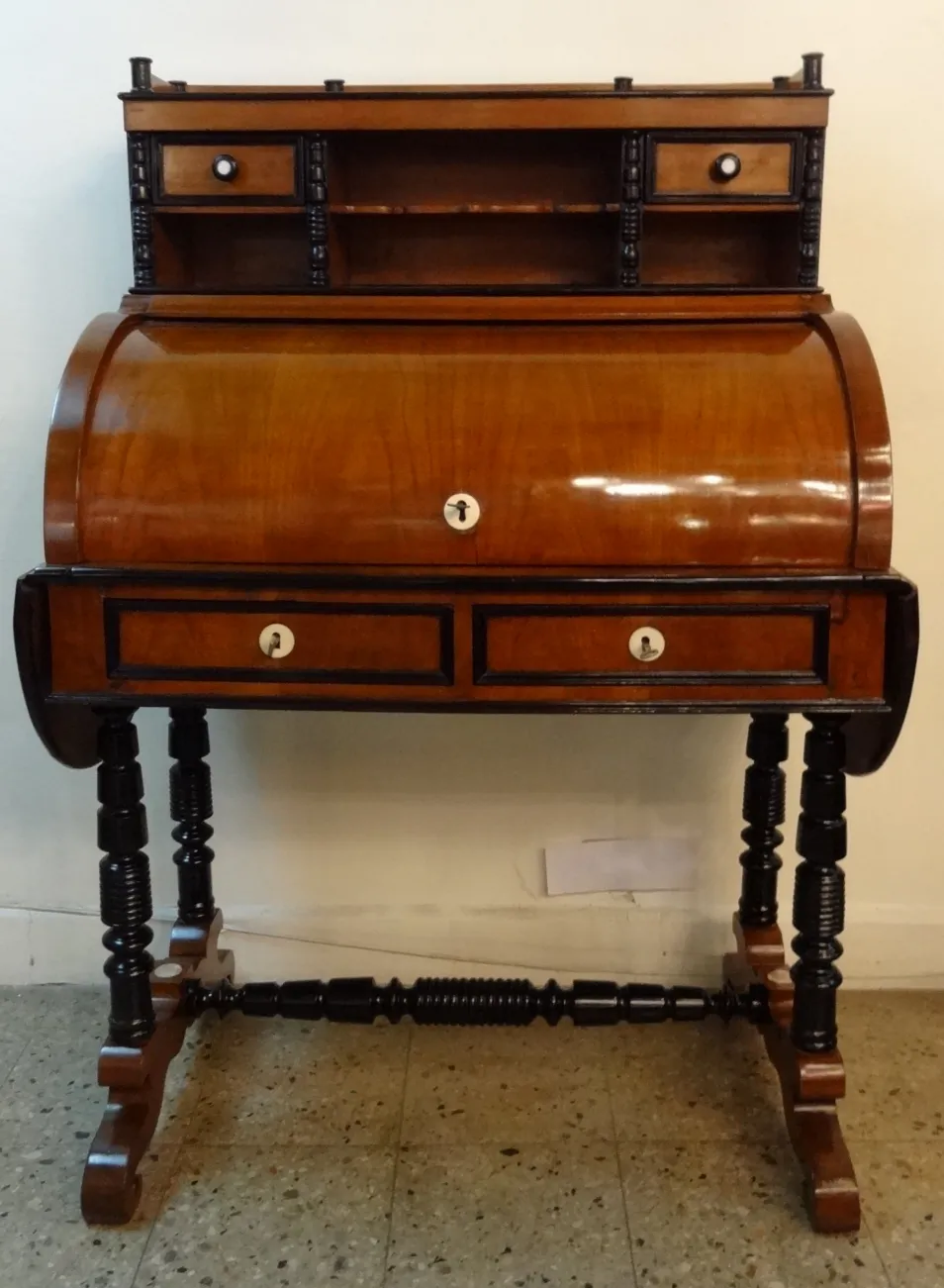 escritorio antiguo de madera con estantes y dos cajones, fondo neutral