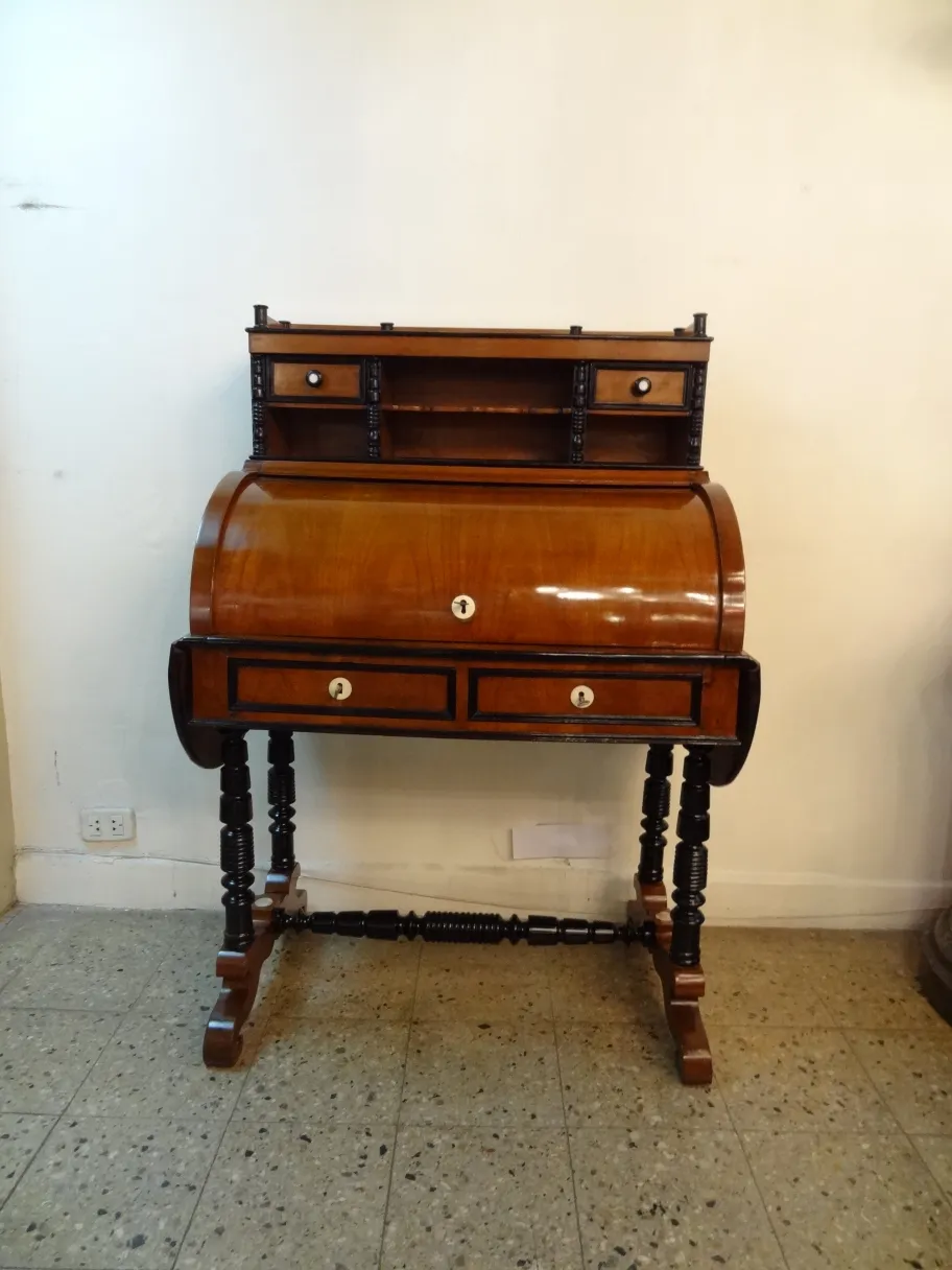 Scrivania antica in stile classico con due cassetti e un ripiano superiore, impostazione semplice.