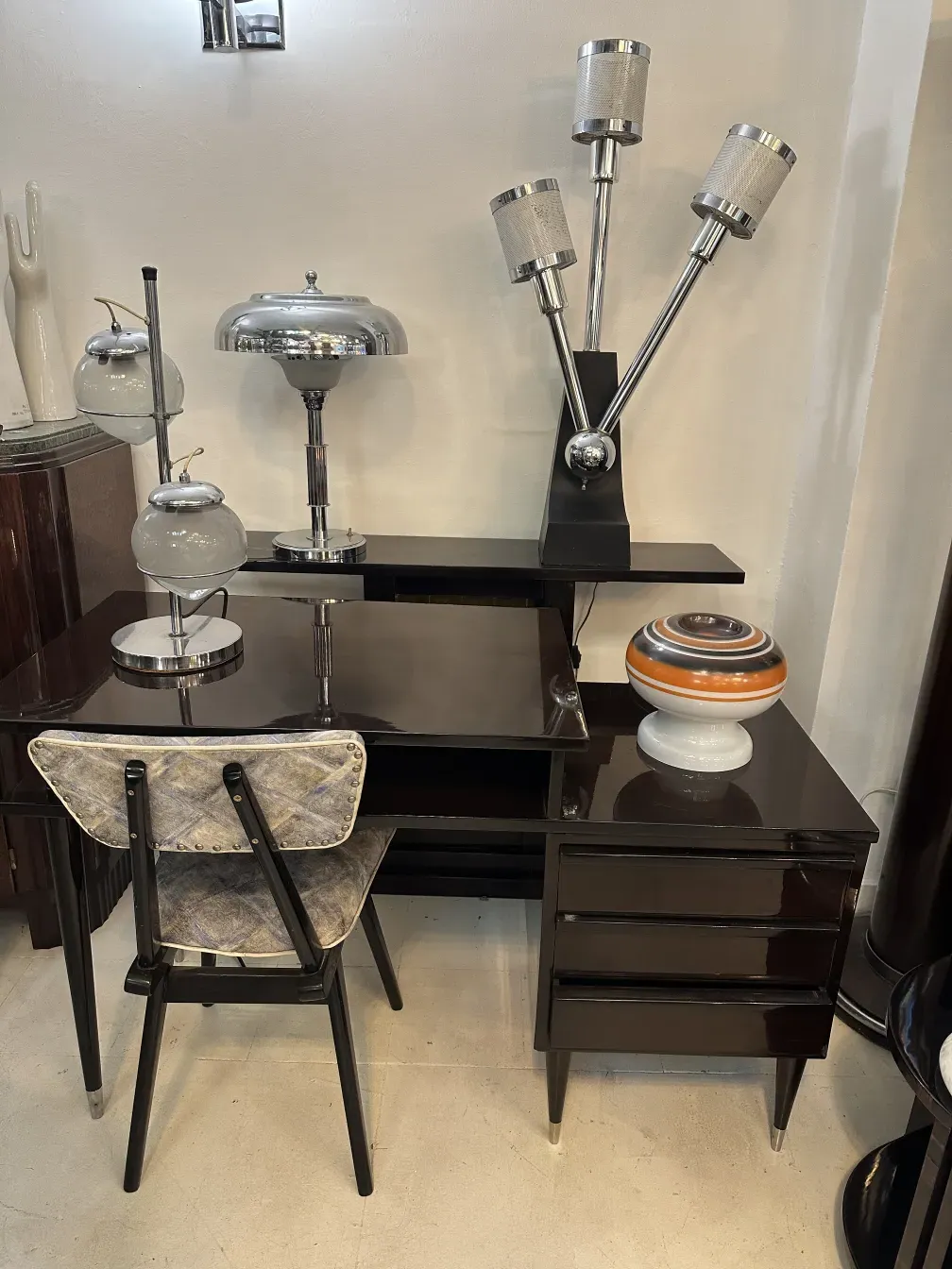 Antique wooden desk with lamp and various decorations