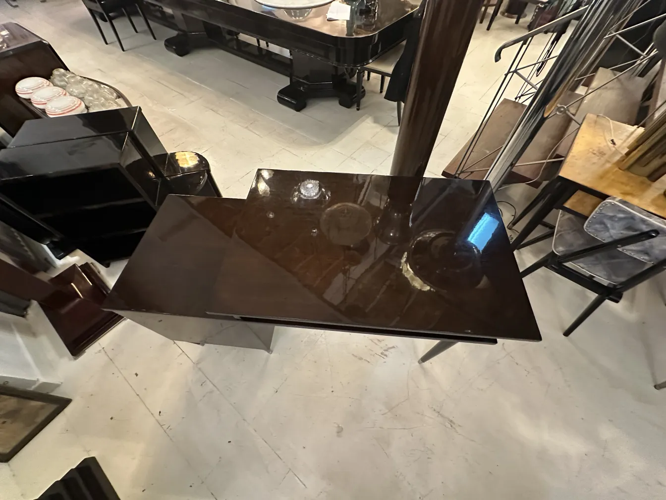 Bureau ancien brillant dans un cadre contemporain, avec des meubles sombres autour.