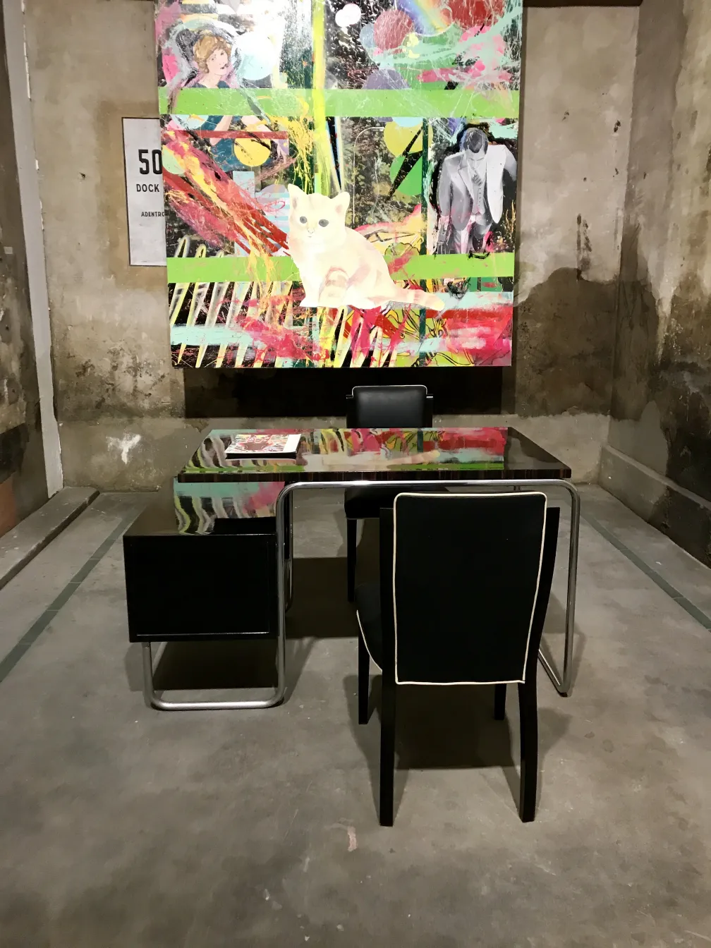 Bureau ancien avec chaises dans un cadre artistique coloré.