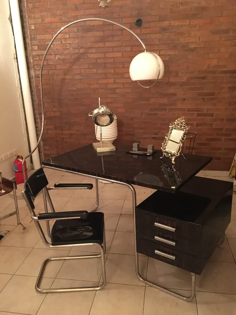 Bureau ancien avec lumière et chaises dans un cadre moderne.
