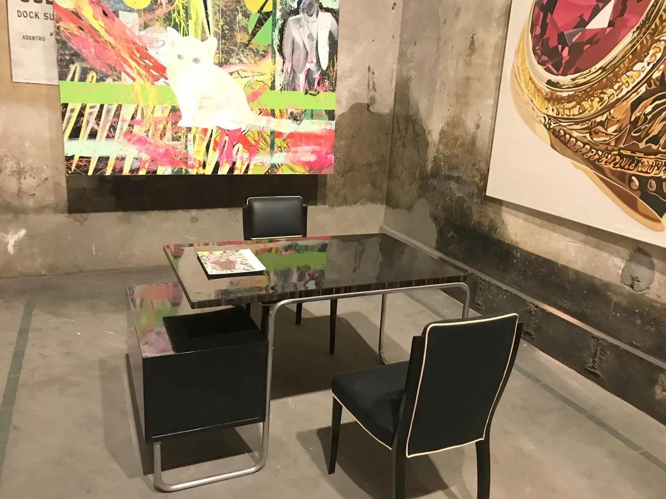 scrivania antica con sedie nere e bianche in un ambiente artistico