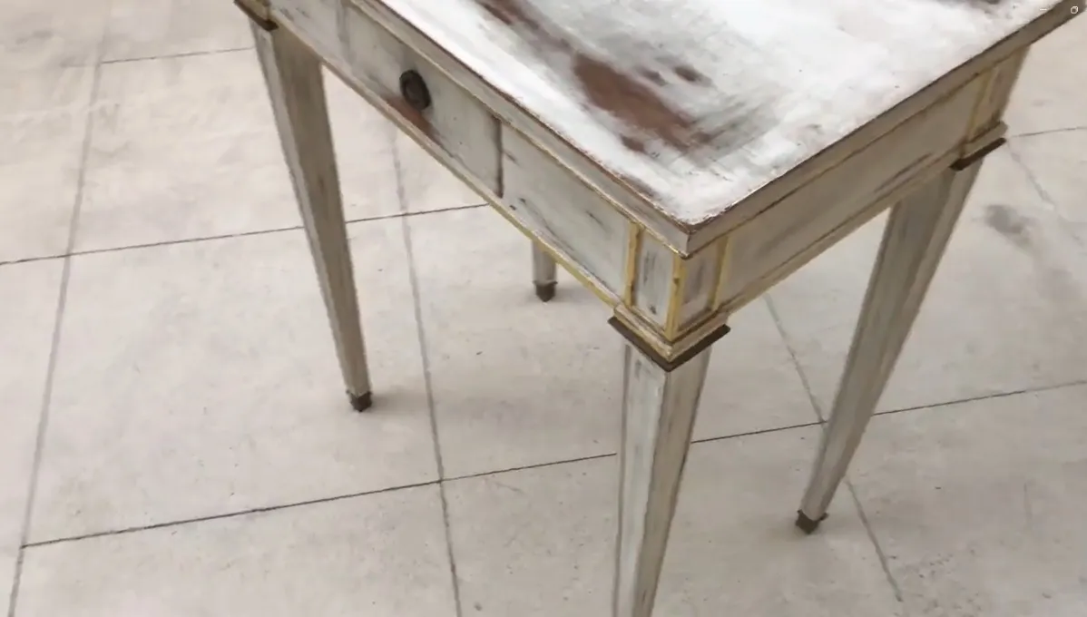 mesa antiga branca com padrão decorativo.