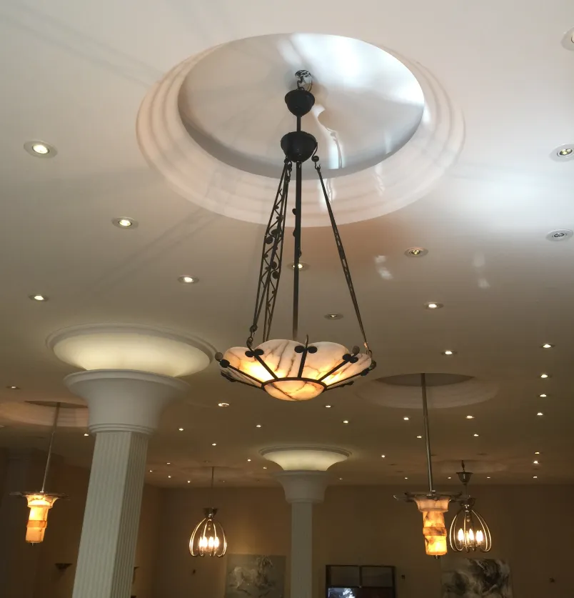 Antique hanging lamp with warm light, set in an elegant space.