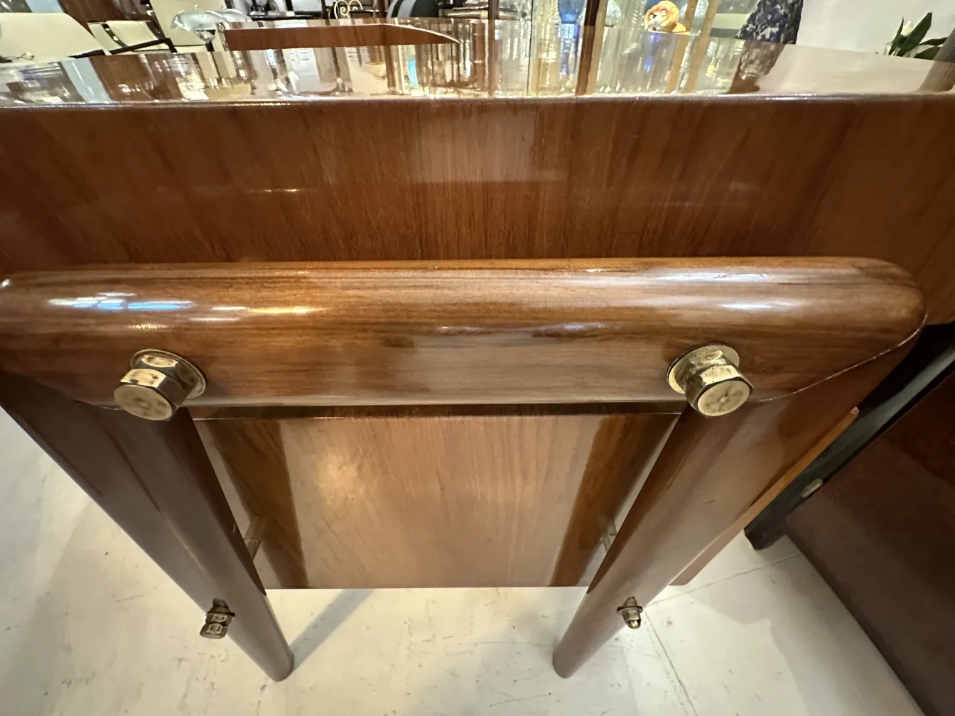 Antiker Schreibtisch aus glänzendem Holz mit goldenen Details in einer gemütlichen Umgebung.